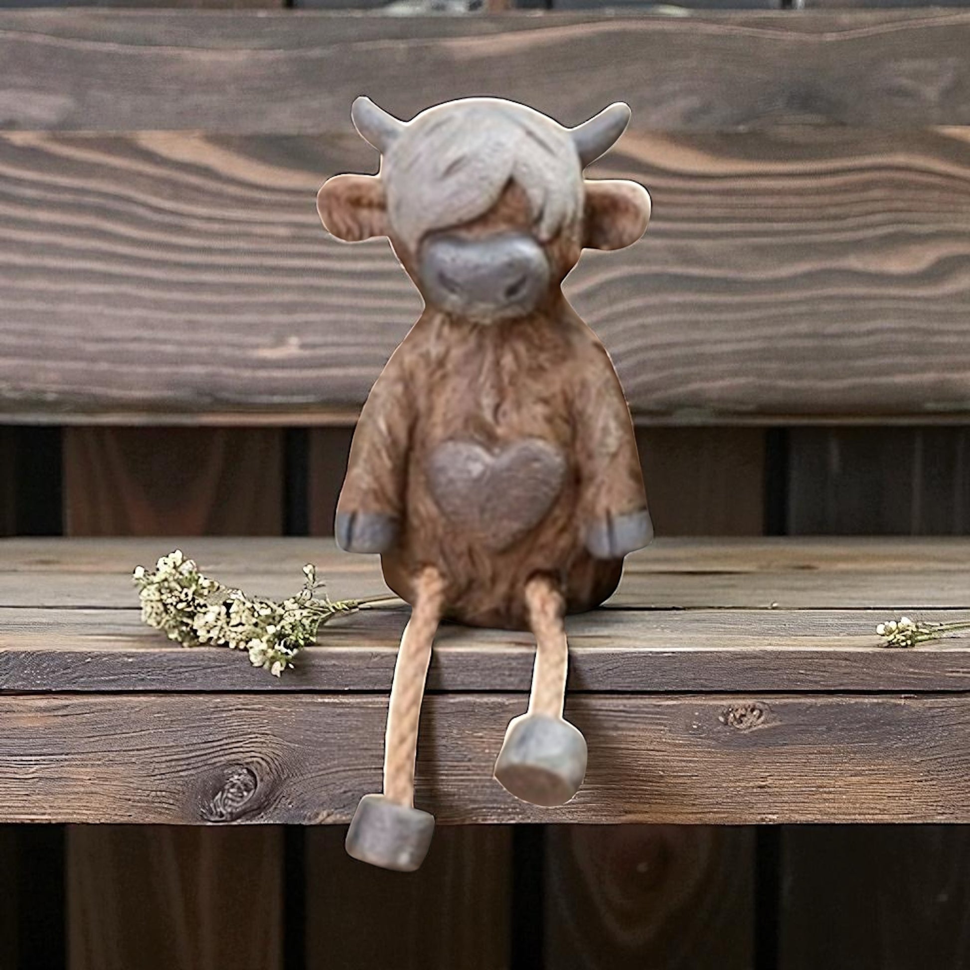 Highland cow shelf sitter ornament with dangling legs on wooden shelf
