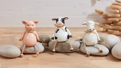 Pig, cow and sheep farm animal shelf sitter ornaments in neutral country style, sitting on a wooden windowsill with dangling legs
