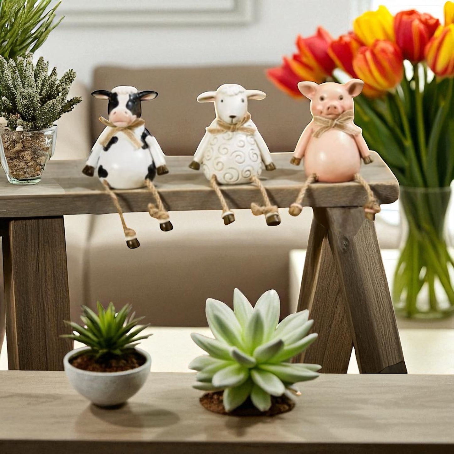 Pig, cow and sheep farm animal shelf sitter ornaments in neutral country style, sitting on a wooden windowsill with dangling legs