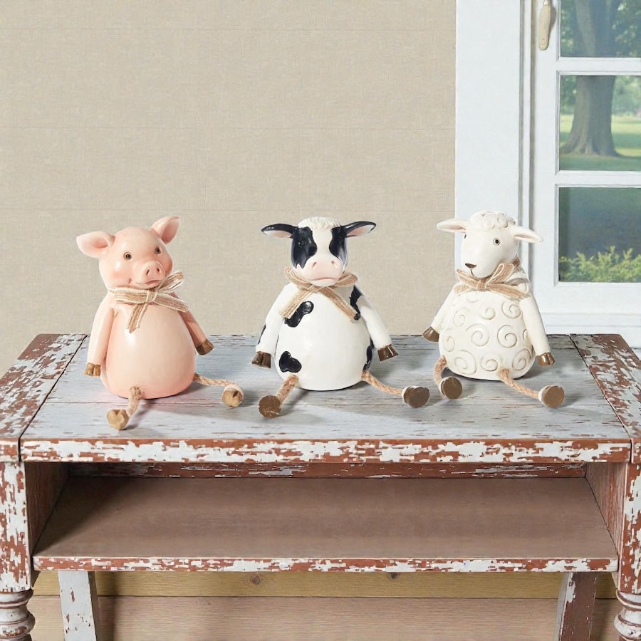 Pig, cow and sheep farm animal shelf sitter ornaments in neutral country style, sitting on a wooden windowsill with dangling legs